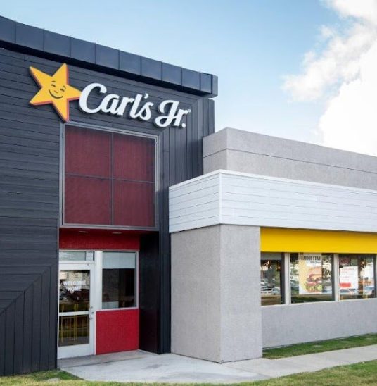Exterior of a Carl's Jr. fast-food restaurant with branded signage and modern design.