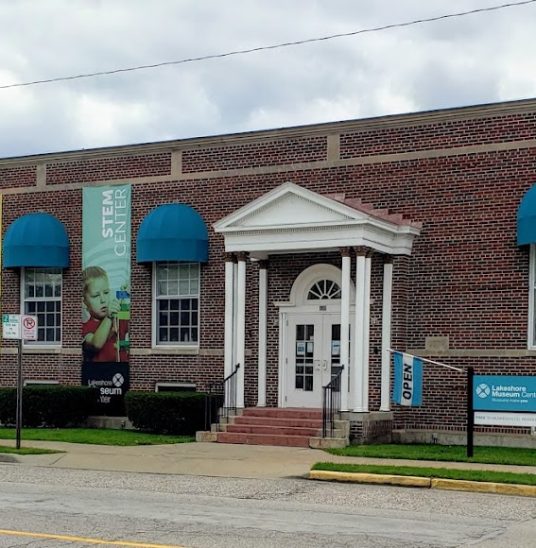 Brick building with blue awnings housing the Lakehore Museum Center STEM Center.