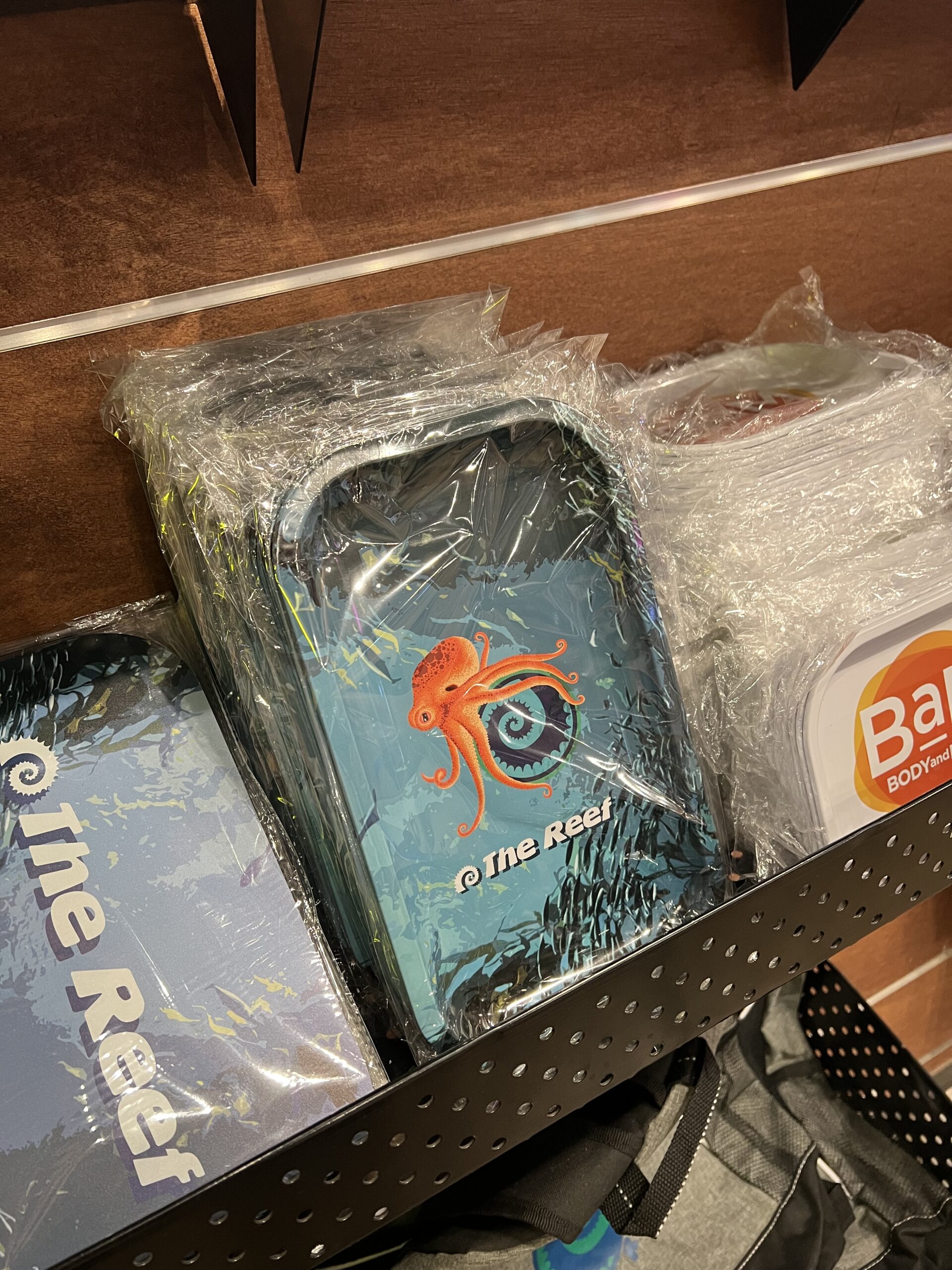 Stack of packaged rolling trays featuring an orange octopus design with the text 'The Reef'